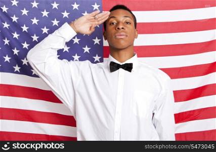 Portrait of young man saluting against American flag
