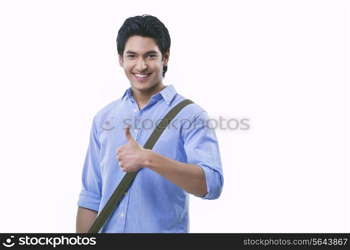 Portrait of young man showing thumps up sign