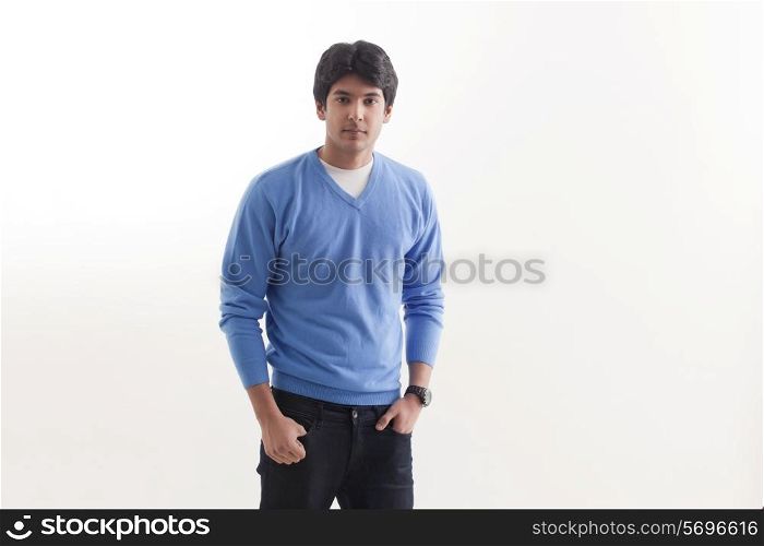 Portrait of young man standing with hands in pockets