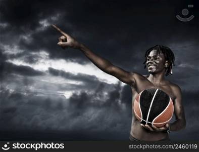 Portrait of young man street basket player against a dark sky