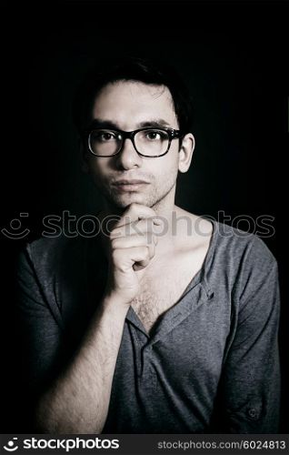 Portrait of young man wearing a glasses on black background