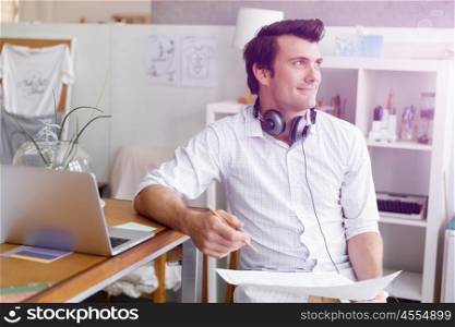 Portrait of young man wearing casual in office. Portrait of young businessman in office with headphones