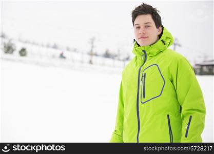 Portrait of young man wearing hooded jacket in snow