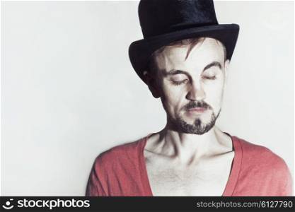 Portrait of young man wearing tall hat on white background