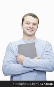 Portrait of young man with book against white background