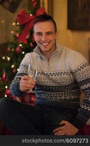 portrait of young man with champagne glass on party celebrate christmas and new year at home