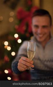 portrait of young man with champagne glass on party celebrate christmas and new year at home