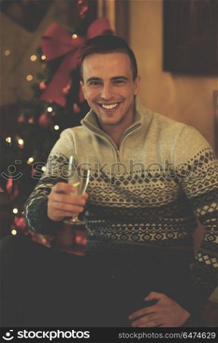 portrait of young man with champagne glass on party celebrate christmas and new year at home. young man with champagne glass on party