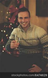 portrait of young man with champagne glass on party celebrate christmas and new year at home. young man with champagne glass on party