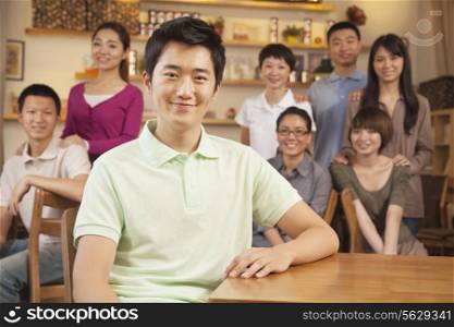 Portrait of young man with group of friends at a coffee shop