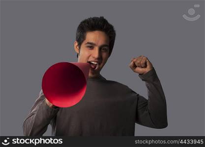 Portrait of young man with megaphone cheering