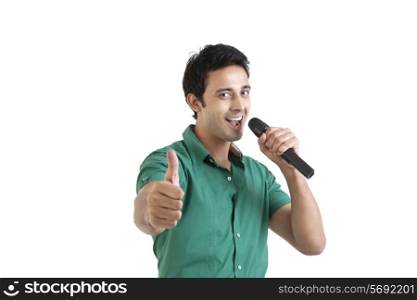 Portrait of young man with microphone giving thumbs up
