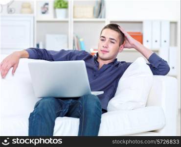 Portrait of young man working on the laptop at home