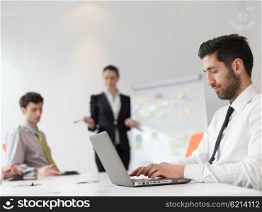 portrait of young modern arab business man with beard at office, group of business people on meeting making presentation in background