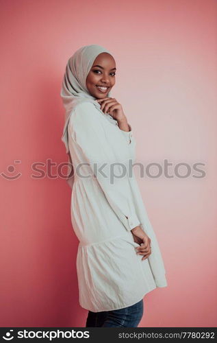 Portrait of young modern muslim afro beauty wearing traditional islamic clothes on plastic pink background. Selective focus. High quality photo. Portrait of young modern muslim afro beauty wearing traditional islamic clothes on plastic pink background. Selective focus 