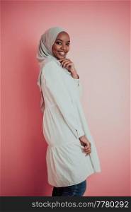 Portrait of young modern muslim afro beauty wearing traditional islamic clothes on plastic pink background. Selective focus. High quality photo. Portrait of young modern muslim afro beauty wearing traditional islamic clothes on plastic pink background. Selective focus 