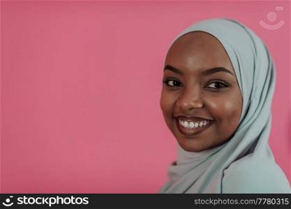 Portrait of young modern Muslim beauty wearing traditional Islamic clothes on plastic pink background. Selective focus. High-quality photo. Portrait of young modern muslim beauty wearing traditional islamic clothes on plastic pink background. Selective focus 