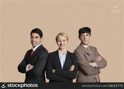 Portrait of young multiethnic team with arms crossed over colored background