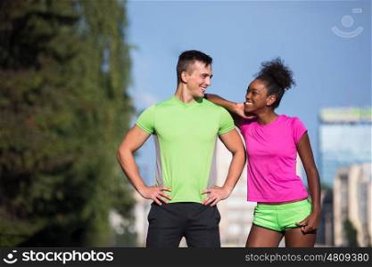 portrait of young multietnic jogging couple ready to run on fresh morning in the city