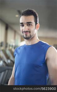 Portrait of young muscular man in the gym