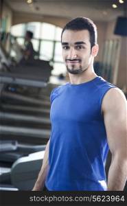 Portrait of young muscular man in the gym