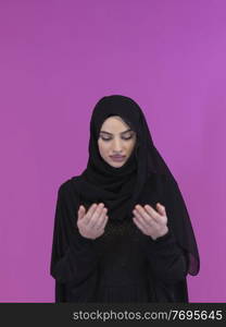 Portrait of young Muslim woman making dua. Arabian girl wearing abaya keeps hands in praying gesture. Representing worship to God and Ramadan Kareem concept