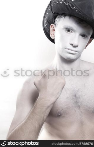 Portrait of young naked man in cowboy hat and with white makeup isolated