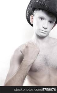 Portrait of young naked man in cowboy hat and with white makeup isolated