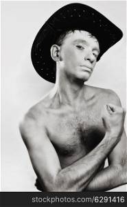 Portrait of young naked man in cowboy hat on white background