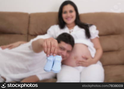 Portrait of young pair showing a pair of socks waiting for the newborn to come