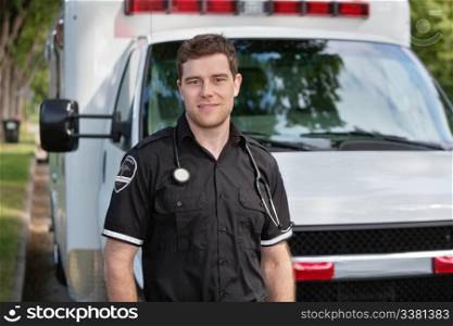Portrait of young paramedic standing in front of white ambulance