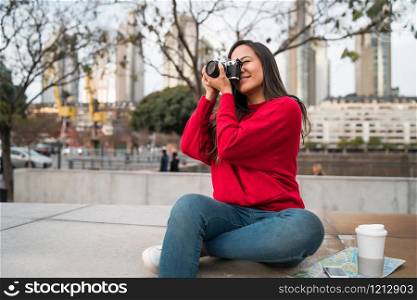 Portrait of young photographer woman using a professional digital camera outdoors. Photography concept