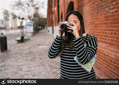 Portrait of young photographer woman using a professional digital camera outdoors. Photography concept
