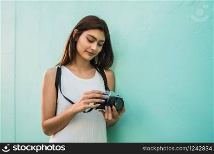 Portrait of young photographer woman using a professional digital camera. Photography concept