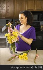 Portrait of young pregnant mother arranging flowers.