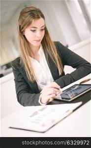 Portrait of young pretty business woman with tablet computer in the office