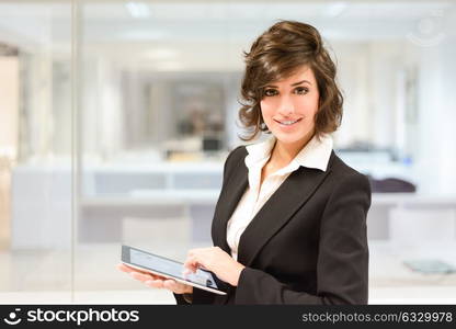 Portrait of young pretty business woman with tablet computer in the office