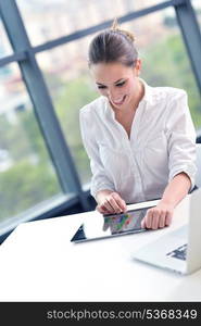 portrait of Young pretty business woman work on notebook computer in the bright modern office indoors