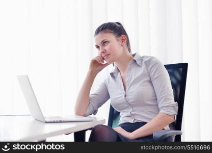 portrait of Young pretty business woman work on notebook computer in the bright modern office indoors