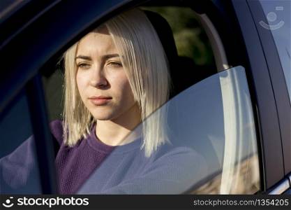 Portrait of young pretty woman in the red car