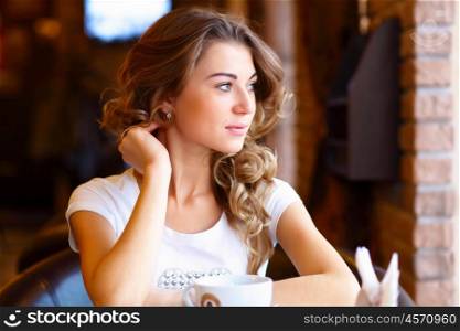 Portrait of young pretty woman sitting in restaurant