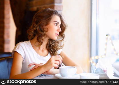 Portrait of young pretty woman sitting in restaurant