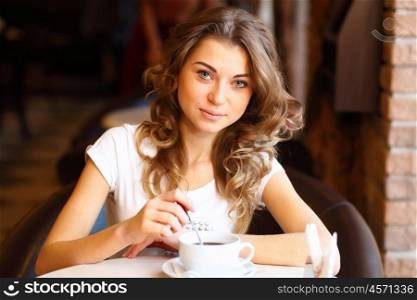 Portrait of young pretty woman sitting in restaurant