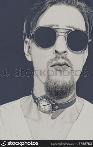 Portrait of young punk in round sunglasses closeup