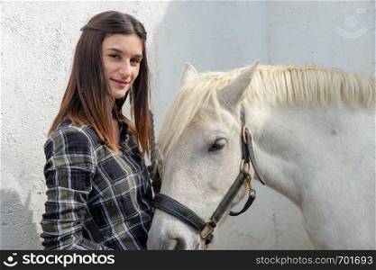 portrait of young rider woman with a white horse