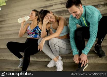 Portrait of young runners resting on stairs after the training