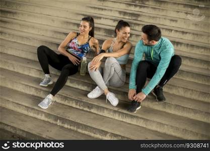 Portrait of young runners resting on stairs after the training