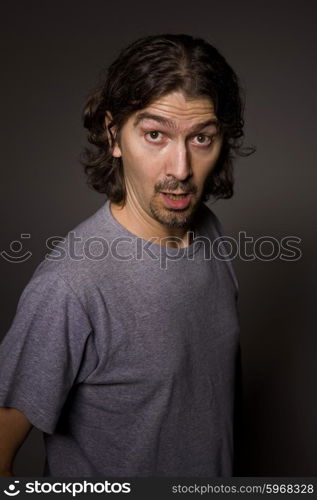 Portrait of young silly man on a dark background