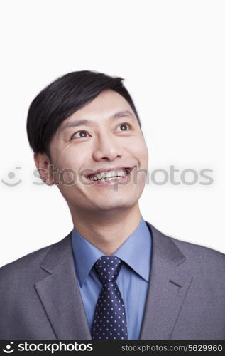 Portrait of young smiling businessman looking up, studio shot