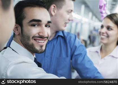 Portrait of young smiling businessman standing on the subway, looking at camera